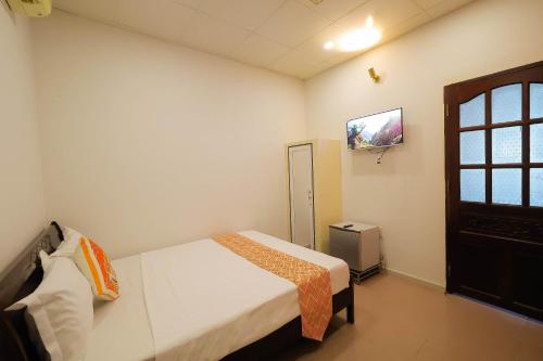 a bedroom with a bed and a tv on the wall at Happy Bear Hostel Phu Quoc in Phu Quoc