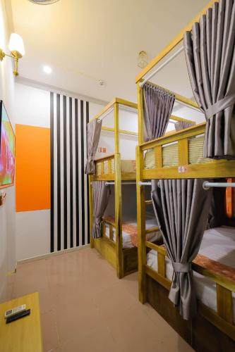 a room with two bunk beds and a tv at Happy Bear Hostel Phu Quoc in Phu Quoc