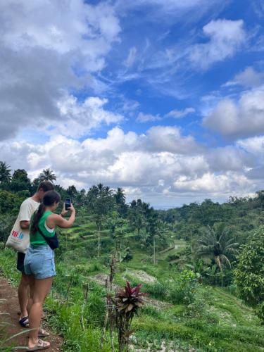 a woman taking a picture of a man taking a picture at PANORAMA BUNGALOWs in Tetebatu