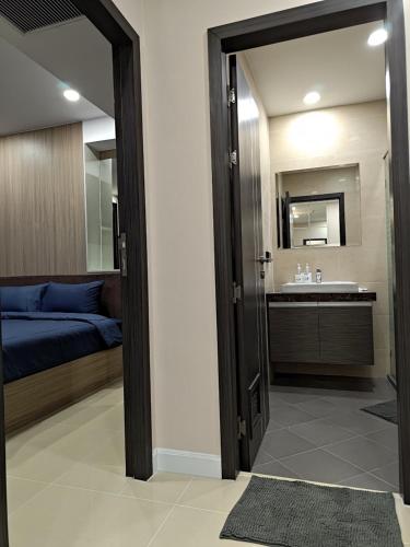 a bedroom with a bed and a sink and a mirror at Dusit Grand Condo View Jomtien By Snap Hosting in Jomtien Beach