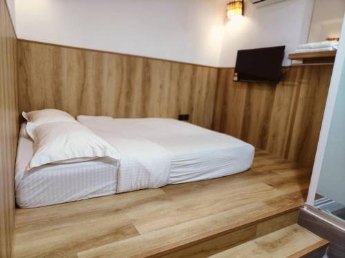 a bed in a room with a wooden floor at Country Hotel in Klang