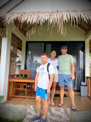 a group of people standing in front of a house at PANORAMA BUNGALOWs in Tetebatu
