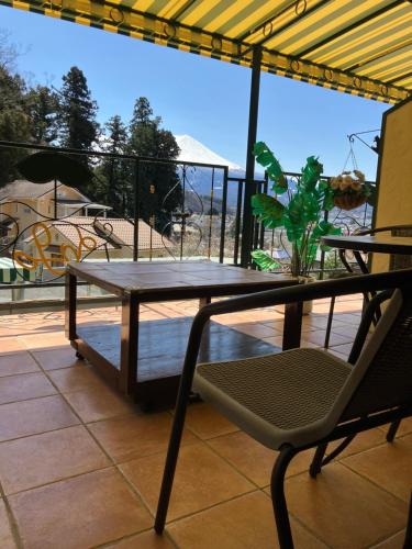 a table and a chair on a balcony at La Posada in Fujikawaguchiko