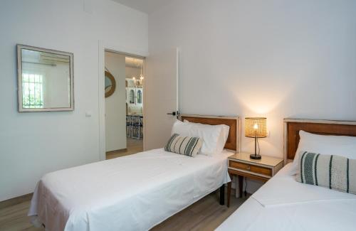 a bedroom with two beds and a table with a lamp at Charming Malaga Retreat, Main House plus Cozy Casita in Málaga