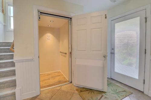 a hallway with a white door and stairs at 7076 - JMJ Seascape in Nags Head