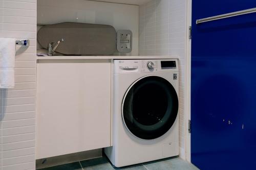 a washing machine in a kitchen with a blue door at Salamanca Wharf Hotel in Hobart