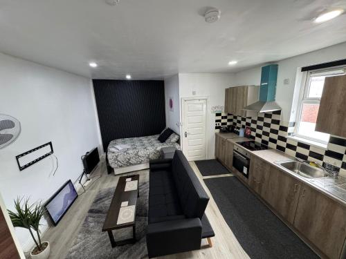 a living room with a couch and a bed in a room at Self-Contained Studio with kitchen & bathroom - Warm Welcome Inn , Stirchley in Birmingham