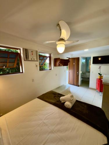 a large white bed in a room with a ceiling at Pousada Janellas do Mar in Búzios