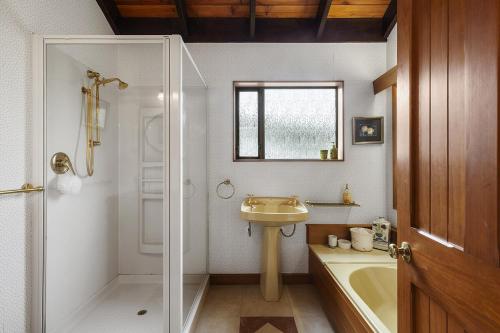 Un baño con lavabo, bañera y ducha. en Karori park side villa, en Wellington