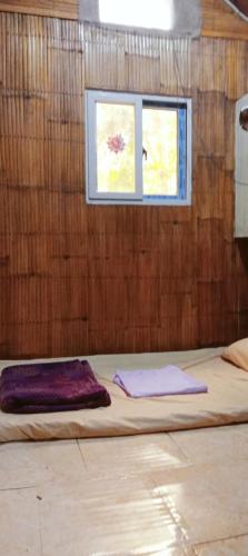 a bed in a room with a window at SECLUDED GLAMPING YOGA SAMADHI fan 2 kubos 8 pax in Rimus