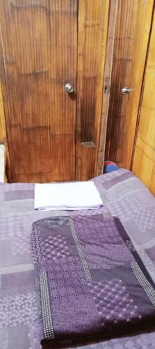a bed with a purple blanket on top of it at SECLUDED GLAMPING YOGA SAMADHI fan 2 kubos 8 pax in Rimus
