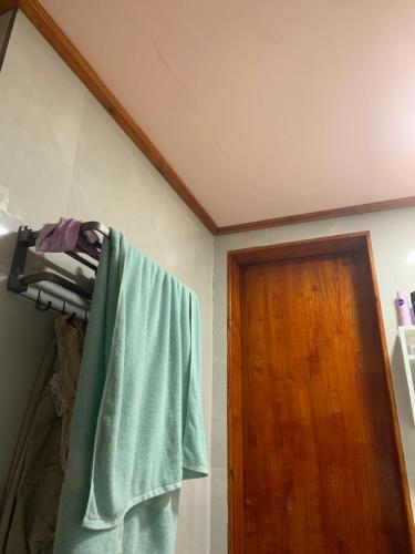 un asciugamano appeso su un appendiabiti accanto a una porta di Room for rent a Hithadhoo
