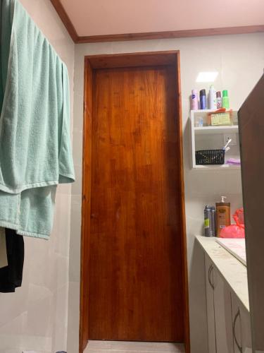 un bagno con una porta di legno in un bagno di Room for rent a Hithadhoo