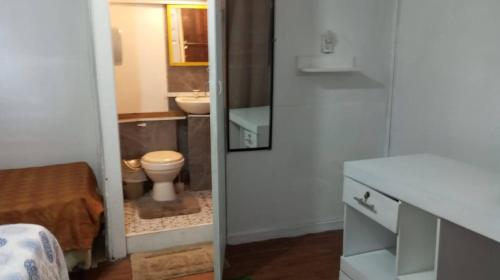 a bathroom with a toilet and a sink at Hotel Victoria s Beach House in Roatan