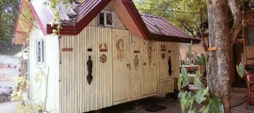 a small wooden house with a red roof at SECLUDED GLAMPING YOGA SAMADHI fan 2 kubos 8 pax in Rimus
