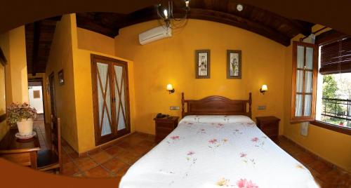 1 dormitorio con 1 cama grande en una habitación con paredes amarillas en Hotel Enrique Calvillo en El Bosque