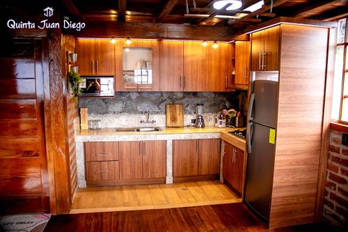 a kitchen with wooden cabinets and a stainless steel refrigerator at Quinta Juan Diego Patate in Patate