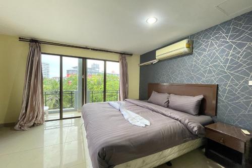 Ένα ή περισσότερα κρεβάτια σε δωμάτιο στο Lucky Inn Suite Pattaya