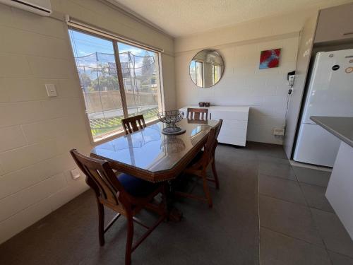 a dining room with a table and chairs and a refrigerator at Mount golf & beach retreat in Mount Maunganui