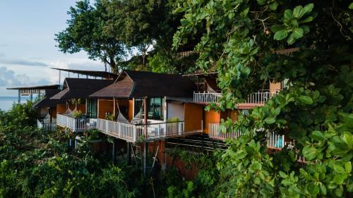 ein Haus an der Seite eines Hügels mit Bäumen in der Unterkunft Chareena Hill Beach Resort in Ko Lipe