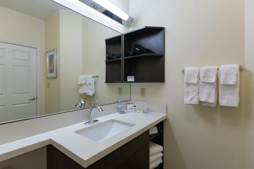 a bathroom with a sink and a large mirror at Candlewood Suites San Marcos by IHG in San Marcos