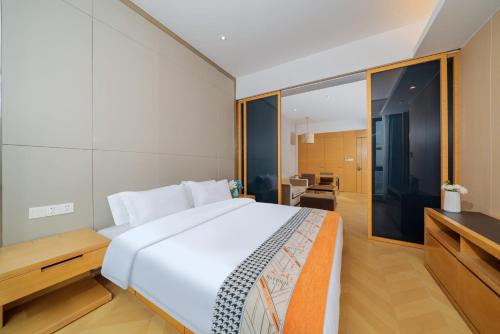 a bedroom with a large white bed and a television at Sheraton Guangzhou International Service Apartment (Pazhou Convention and Exhibition Center Branch) in Guangzhou