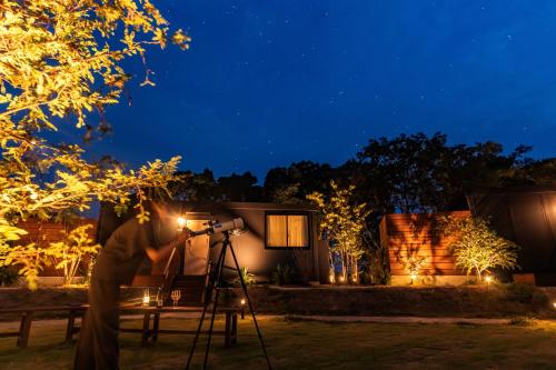 a person taking a picture with a camera at night at amarancia cottage hugging nature house in Minamiawaji