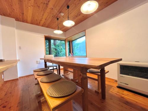 a dining room with a table and some windows at Fuku Chalet in Hakuba