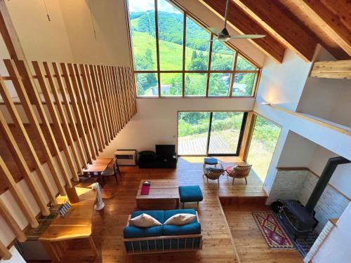 a living room with a staircase and a large window at Fuku Chalet in Hakuba