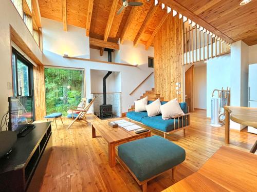 a living room with a blue couch and a table at Fuku Chalet in Hakuba