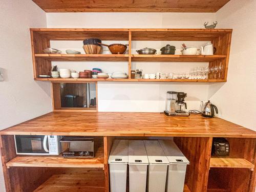 a kitchen with wooden shelves and a counter at Fuku Chalet in Hakuba