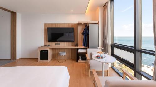 a living room with a television and a table at The Van Hotel in Ulsan