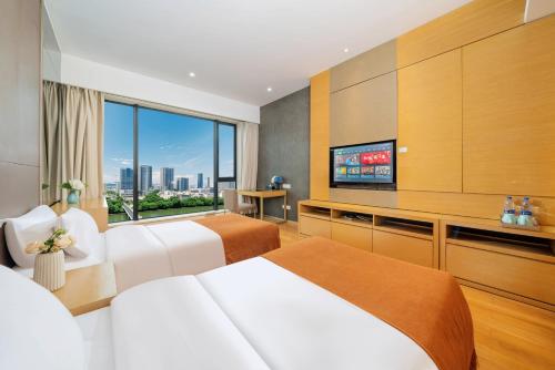 a hotel room with two beds and a flat screen tv at Sheraton Guangzhou International Service Apartment (Pazhou Convention and Exhibition Center Branch) in Guangzhou