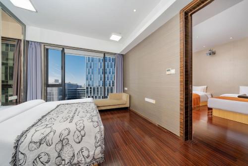 a bedroom with a bed and a large window at Sheraton Guangzhou International Service Apartment (Pazhou Convention and Exhibition Center Branch) in Guangzhou