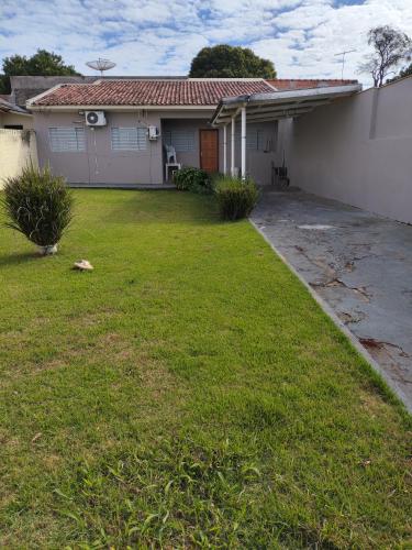 a house with a grass yard in front of it at Casa Tokio in Londrina