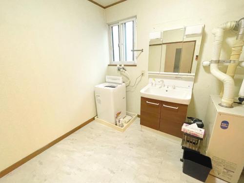 a small bathroom with a sink and a refrigerator at 青森駅近7名まで同一料金ファミリー向け小学生添い寝無料コンドフルカワ青森 in Aomori