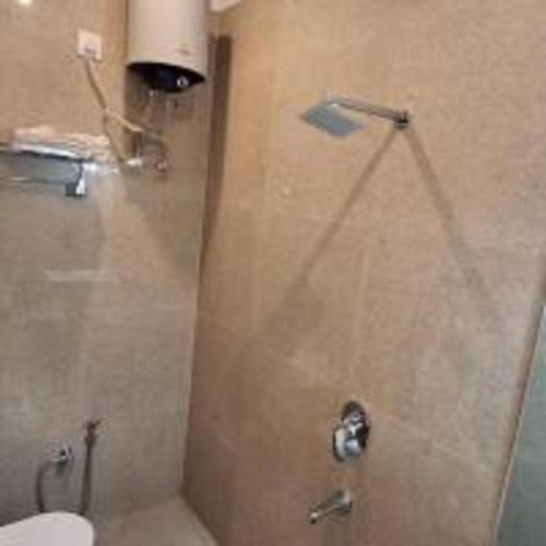a shower with a glass door in a bathroom at Aroma Prayagraj By StayApart in Prayagraj