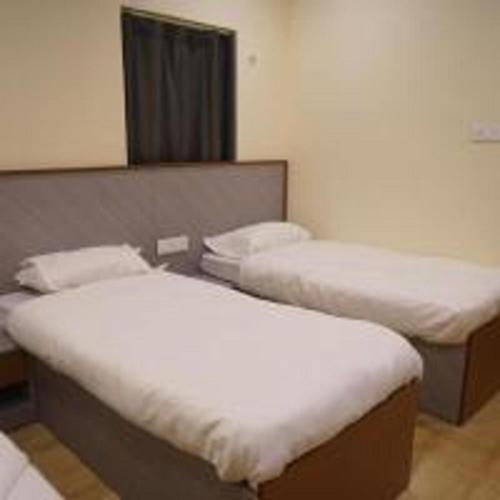 a room with two beds in a room at Aroma Prayagraj By StayApart in Prayagraj