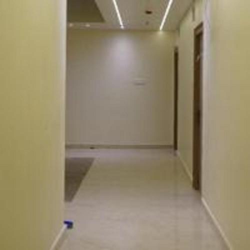 an empty hallway in a building with a white floor at Aroma Prayagraj By StayApart in Prayagraj