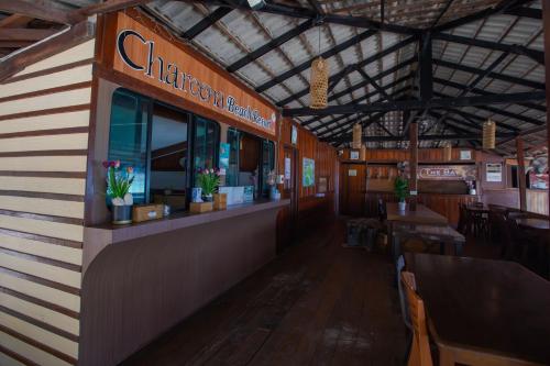 a restaurant with a counter and tables and chairs at Chareena Beachside in Ko Lipe