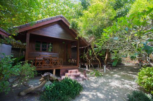 a wooden cabin with a picnic table in front of it at Chareena Beachside in Ko Lipe