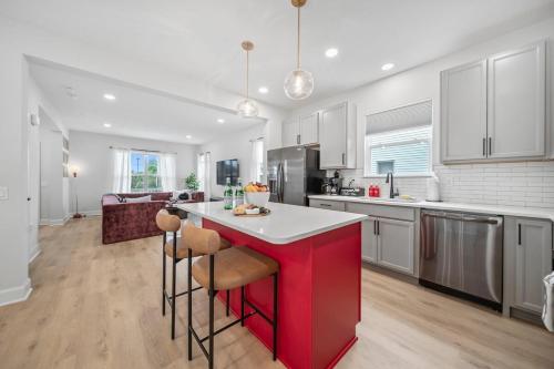 a kitchen with a red island in the middle at Hot Tub - Mins to Short North - Retro Game Room in Columbus