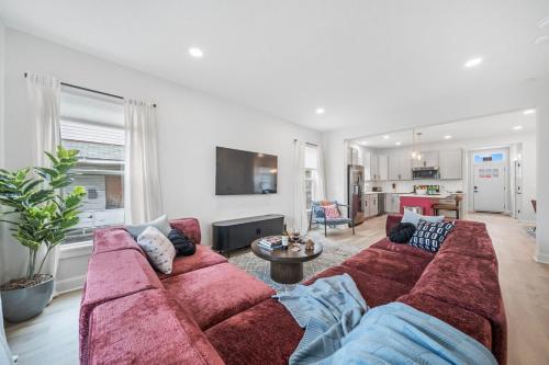 a living room with a red couch and a table at Hot Tub - Mins to Short North - Retro Game Room in Columbus