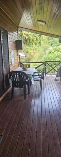 a wooden deck with a table and chairs on it at Ray's B&B in Matei