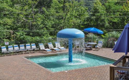 a fountain in a pool with chairs and an umbrella at Eagles Nest in Gatlinburg