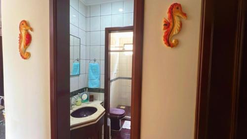a bathroom with a sink and two seahorses on the wall at Salinas AzulGávea in Salinópolis