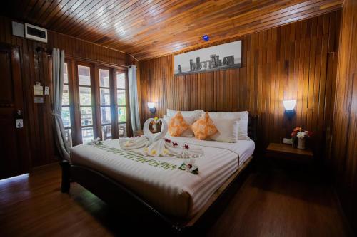 a bedroom with a large bed with wooden walls at Chareena Beachside in Ko Lipe
