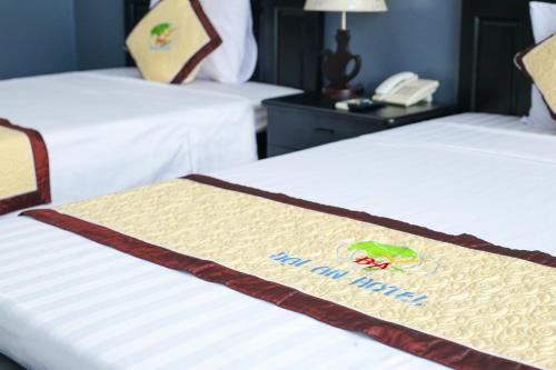 a hotel room with two beds and a phone at Khách sạn Đại An Ninh Bình in Ninh Binh