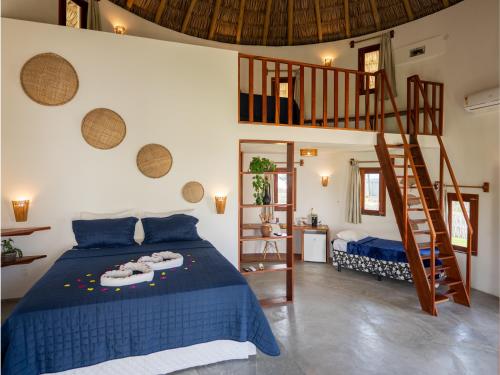 a bedroom with a bed and a spiral staircase at VentoVinte Beach Club in Flecheiras