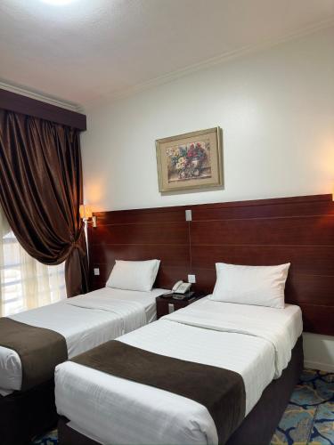 a hotel room with two beds and a window at فندق مراج طيبه Mirage Taiba Hotel in Medina